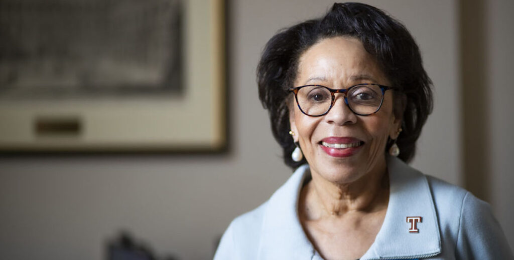 The late acting president of Temple University, JoAnne Epps, a Black women with neck-length hair and glasses.