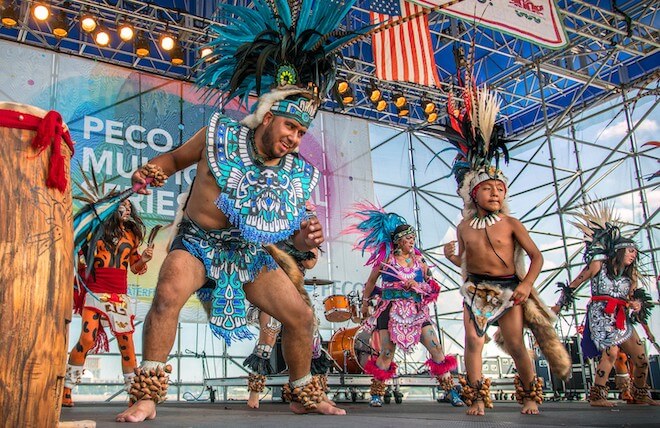 Men in beaded loincloths and feather headdresses dance onstage at the Mexican Independence Day Festival in Philadelphia.