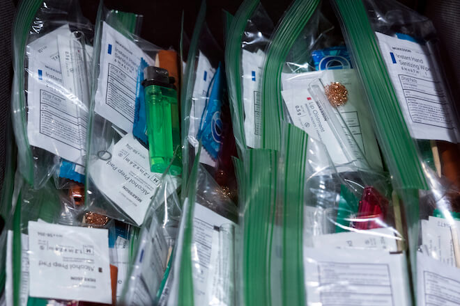 A pile of zipper plastic bags contain safe-use kits or injection kits containing syringes, sterile water, alcohol prep pads, filters, tourniquets, antibacterial ointment and more supplies.