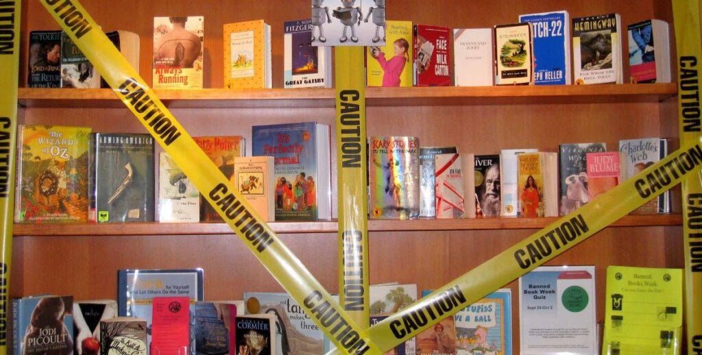 Library book shelves with various classic works of literature old and new protected by yellow caution tape