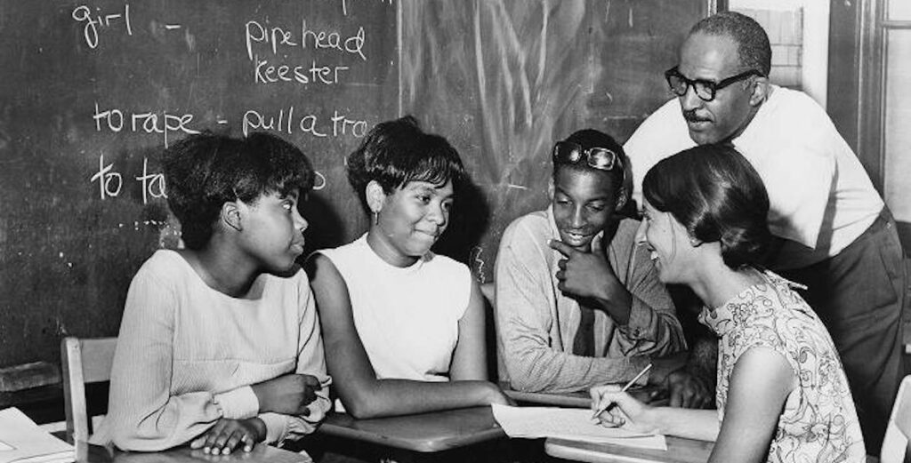 Black-and-white photo of Three Simon Gratz High School students, a teacher, and Marcus Foster. Courtesy of the Temple Archives.