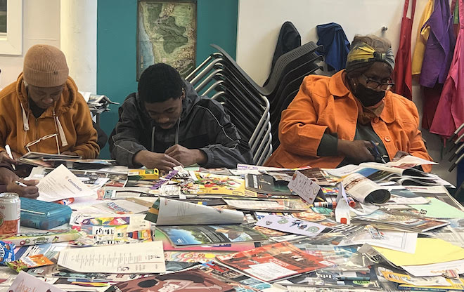 Three African Americans sit behind a table full of pages of colorful magazines, working on a art project as an event in Connectedly's GrandFamily program.