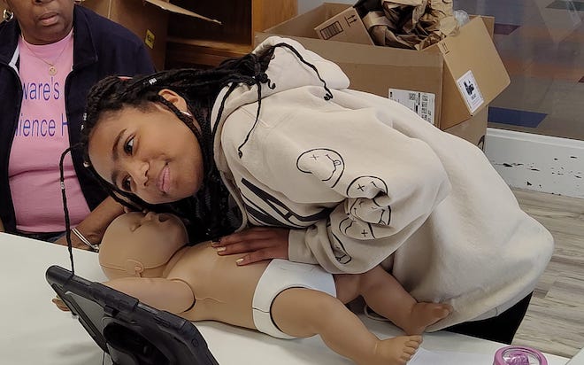 A student practices infant CPR at the Delaware Resilience Hub.