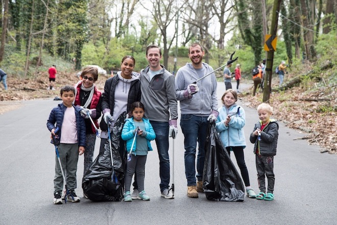 Five adults and four children stand with garbage bags and grabbers in Fairmount Park's Wissahickon section.