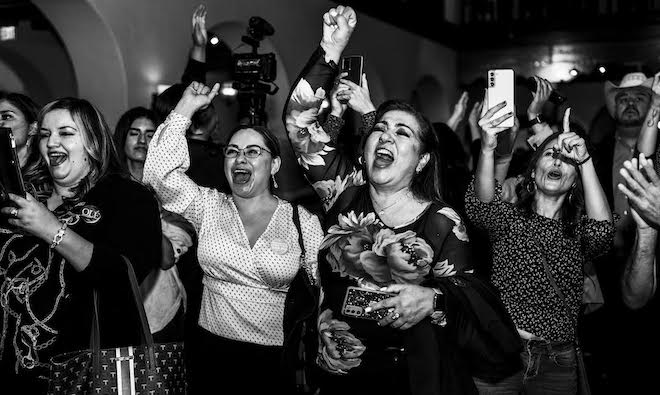 A black-and-white portrait of Universal childcare proponents in New Mexico celebrate the passage of an amendment guaranteeing early childhood education.