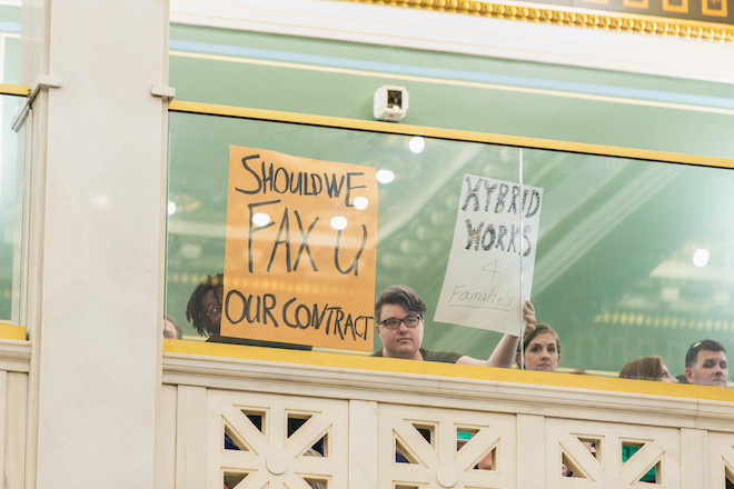 Return to office protestors display signs saying "Should we fax u our contracts?" and "Hybrid works 4 families." at a June City Council meeting. Photo courtesy of Philadelphia City Council.