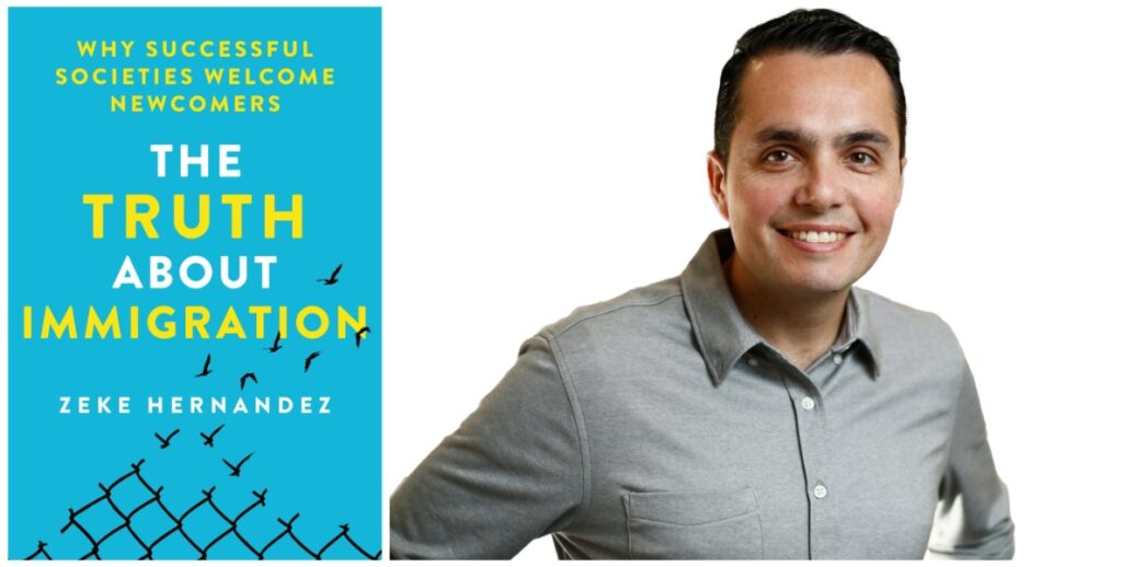 The cover of a book jacket reads: The Truth About Immigration. Next to the cover stands author Zeke Hernandez, a dark-haired man in a grey button-down shirt; he is smiling.
