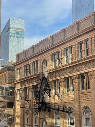 The brown brick main building of Drexel University with the Cira Center South building in the background