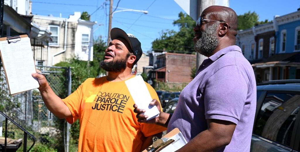 Sergio Hyland from the Abolitionist Law Center and Kevin Butler, president of the Philadelphia Gray Panthers, visit a resident whom they'd like to register to vote.