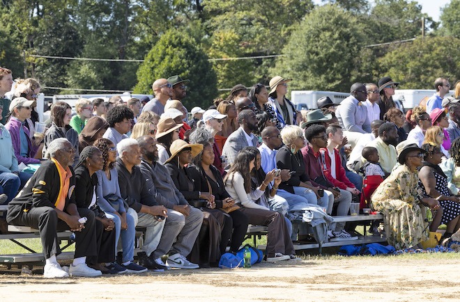 Spectators sit on a short bleachers at the Philadelphia Polo Classic.