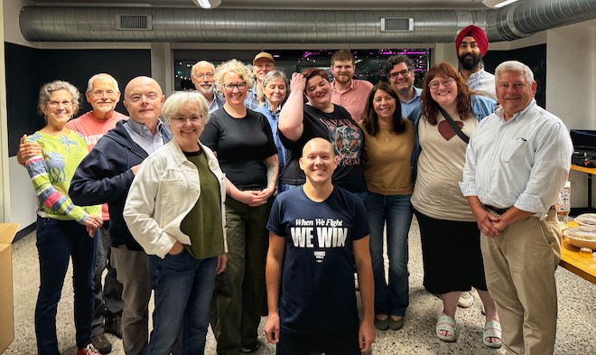 Arash Singh (far right, back) stands among other Changing the Conversation Together volunteers.