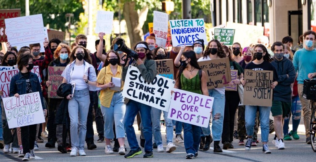 A group of students hold signs with pro-green energy and anti-fossil fuel slogans demonstrate during the 2022 Climate Strike