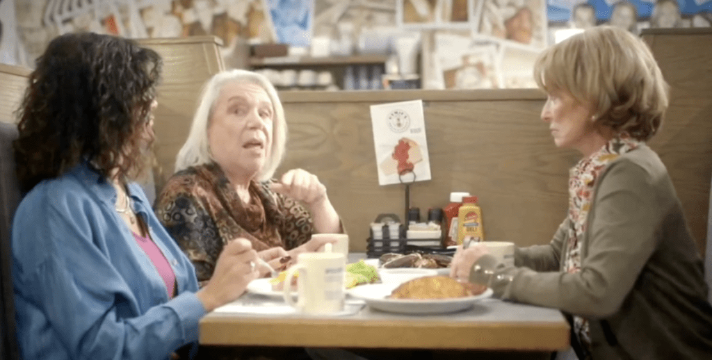 In a still shot from the Republican Jewish Coalition Victory Fund's commercial "Deli Talk," three older white women sit in a booth in Hymie's Deli and talk over plates of latkes and black-and-white cookies.