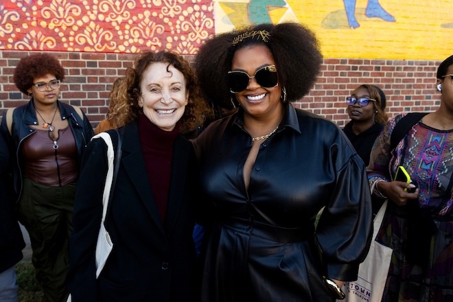 Jane Golden stands beside Jill Scott an din front of The “Luminaries: The Coronation” a mural that honors the Girls' High distinguished alumnae, including Scott, October 10, 2024. Photo by Gustavo Garcia for Colibri Workshop.