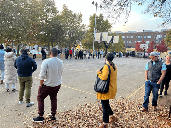 A line wraps around the basketball court at the polls at Adaire Elementary early on Election Day 2024. By Courtney DuChene.