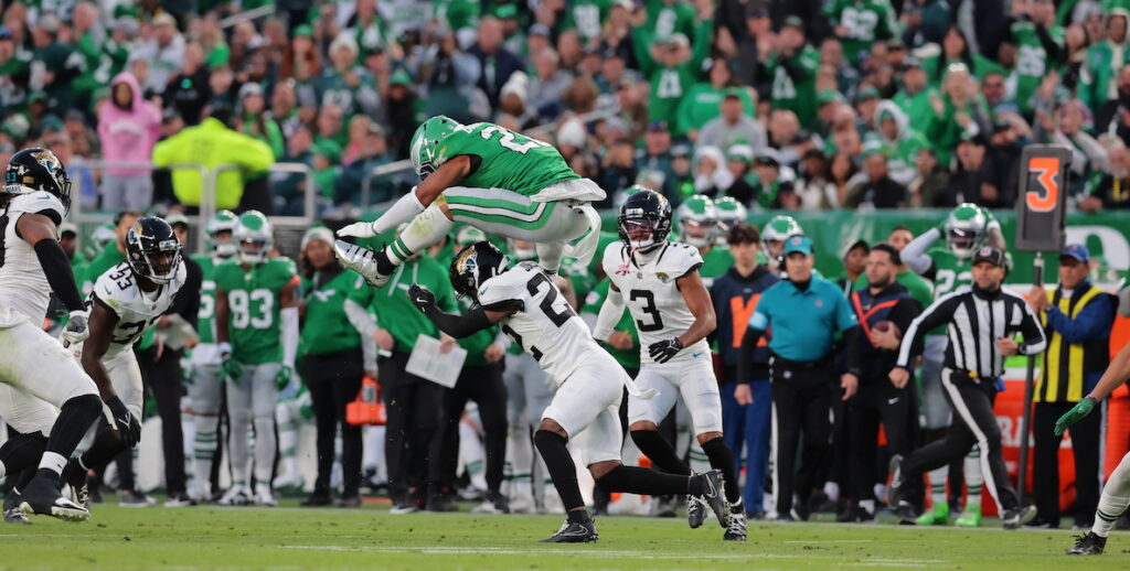 On November 3, 2024, Eagles' running back Saquon Barkley leaps over Jacksonville Jaguar Jarrian Jones.