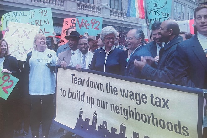 Von Seldeneck and fellow members of the "briefcase brigade," including the future Mayor Michael Nutter. A group of business people carry a banner protesting the Philadelphia Wage Tax. 