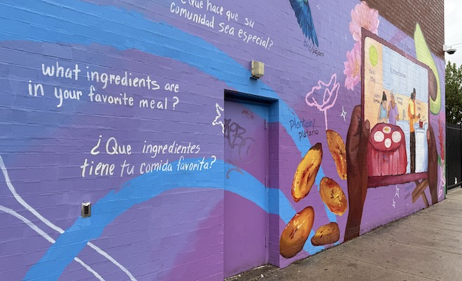 A bright mural outside Julia de Burgos Elementary School depicts foods and words in Spanish and English.