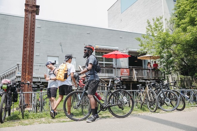Cyclists park their bikes outside a cement-block building that is Conshochoken Brewing Company.